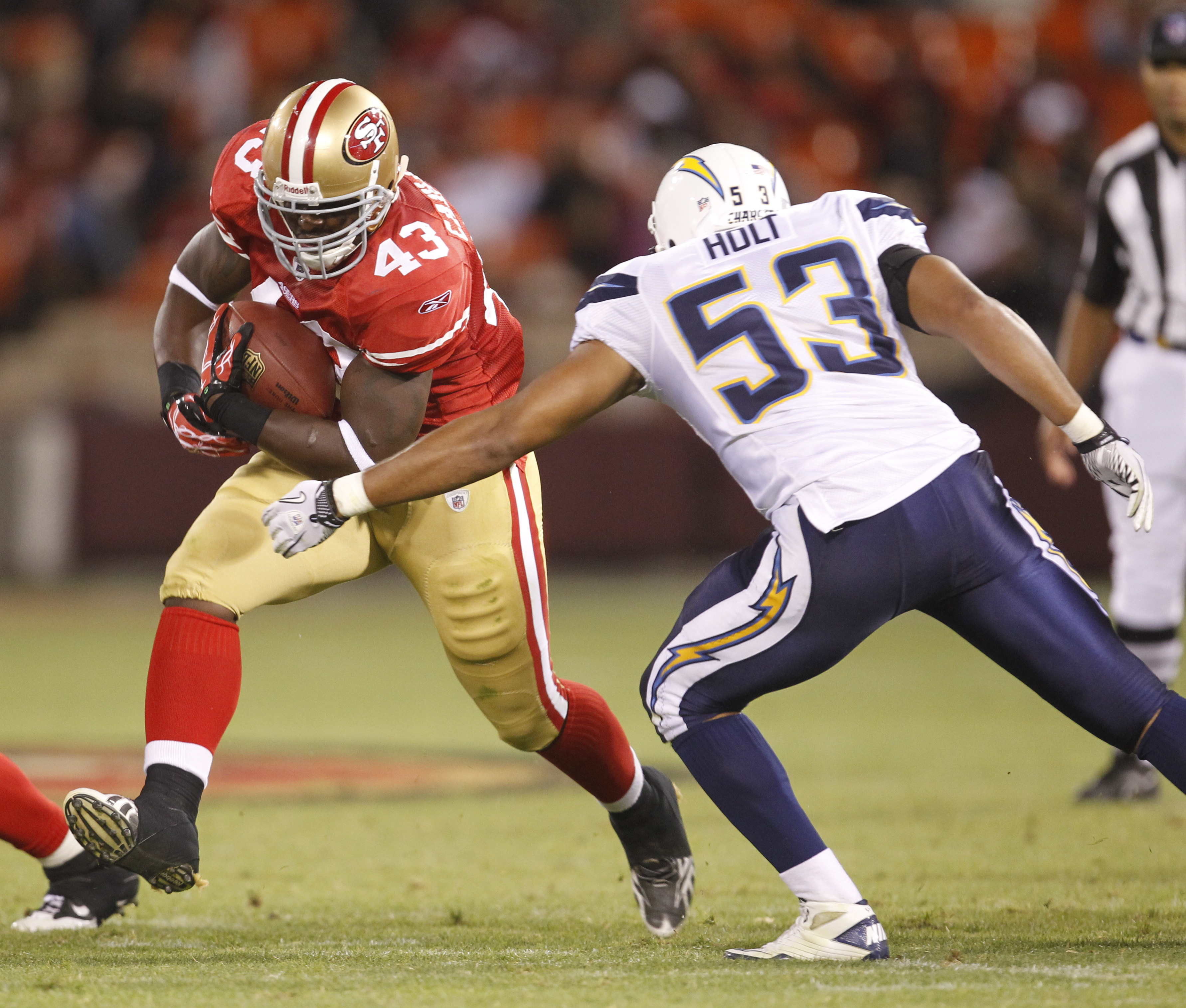 Jehuu Caulcrick #43 stiff-arming a Chargers defender for the San Francisco 49ers